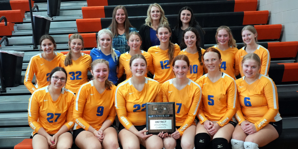 volleyball team sitting with runner up plaque