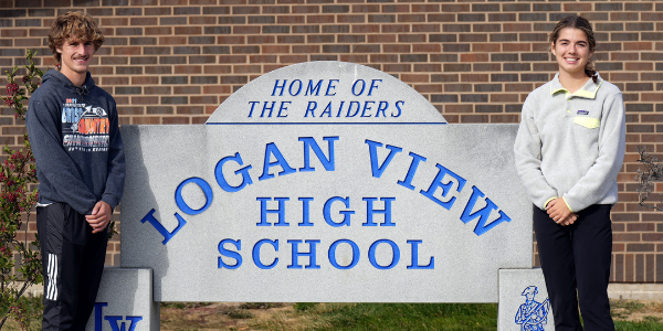 two students standing by school entrance