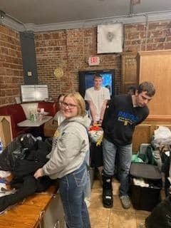 Three people helping put clothes away in a store