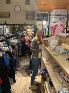 Two people helping sort clothing in a store